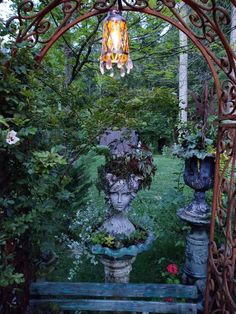 a garden area with statues and lights hanging from the ceiling