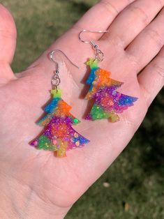 Each set of colorful neon glow in the dark Christmas tree earrings are handmade to order, therefore no two pairs are identical! Every resin jewelry piece in my shop is slightly unique and one of a kind. However, I try to get as close to the photos as possible :)  Made with sterling silver plated fishhook earrings (clear rubber backing included). Hypoallergenic & nickel-free. Christmas trees are approximately 43mm x 34mm (or 1.69in x 1.34in), and are made with uv resin, colorful glow in the dark Resin Holiday Earrings, Funky Rainbow Earrings As Gift, Multicolor Holiday Dangle Earrings, Fun Multicolor Resin Earrings, Resin Christmas Tree Earrings, Rainbow Accessories, Dark Christmas, Winter Jewelry, Christmas Tree Earrings