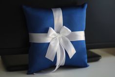 a blue pillow with a white ribbon tied around it