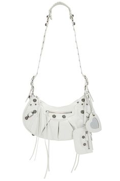 Find BALENCIAGA Le Cagole Shoulder Bag on Editorialist. The Balenciaga Le Cagole Shoulder Bag is crafted from white Arena lambskin leather and features a knotted leather pull. The bag is equipped with a top zip closure, front and back zip pockets with knotted leather pulls, one main compartment with a zip pocket, a removable zip pouch, and a heart mirror. The bag measures approximately 12.5 inches wide, 6.5 inches high, and 3 inches deep. It has a shoulder strap with a 17 inch drop and silver-to Designer Leather Baguette Bag For Mobile Phone, Balenciaga Purse, Heart Mirror, Bag Collection, Braided Strap, Leather Pulls, Big Love, Zip Pouch, White Bag