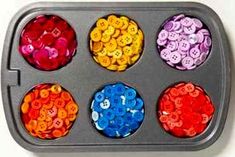 a tray filled with lots of different colored buttons