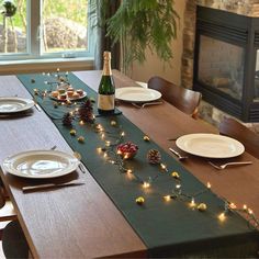 the table is set with plates, silverware and wine bottle for christmas dinner party