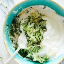 a blue bowl filled with cucumber and yogurt