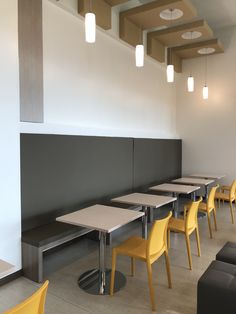 the tables and chairs are lined up against the wall in the dining area, with benches on either side