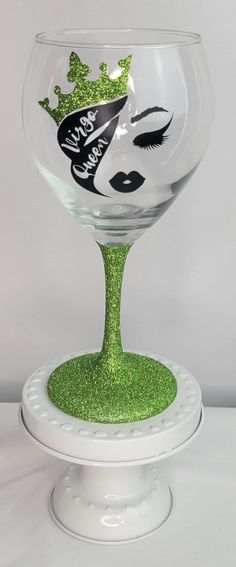 a wine glass decorated with glitter and an image of a woman's face on it