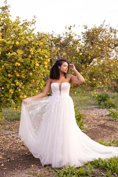 a woman standing in front of an orange tree