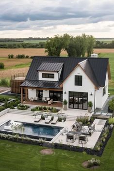 an aerial view of a house with a pool in the foreground and lawn area