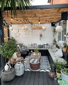 an outdoor living area with potted plants and wicker furniture on the decking