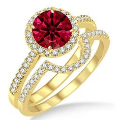 a gold ring with a red stone in the center and two white diamonds around it