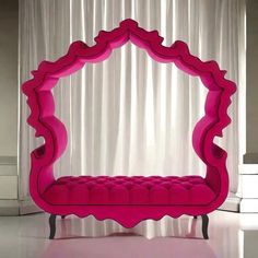 a pink bench sitting in front of a white curtain