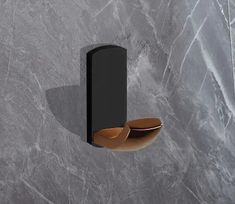 a black wall mounted toilet paper dispenser on a gray marble wall with brown accents