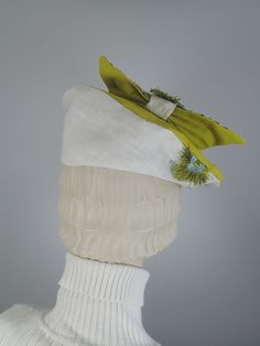 This fun and funky beret-style hat is inspired by a 1940s vintage hat in my collection. It sits asymmetrically on the head at a fairly extreme tilt. The fabric sample used to make this beret was destined for the landfill but it was instead made into something functional and fun. Solid Greenish-yellow cotton fabric top; underside is a white linen with random embroidered flowers in green and blue. It's embellished with a coordinating bow that has a raised, embroidered flower. Colors include blue, Adjustable Curved Brim Beret For Spring, Spring Adjustable Beret With Curved Brim, Retro Fitted Summer Fascinator, Retro Fitted Hats For Spring, Retro Fitted Hat For Spring, Green Flat Cap For Spring, Retro Mini Hats With Short Brim For Spring, Retro Mini Hat With Short Brim For Spring, Retro Brimmed Mini Hat For Spring