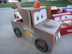 a cardboard toy truck with cars in the background