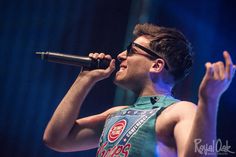 a young man singing into a microphone on stage