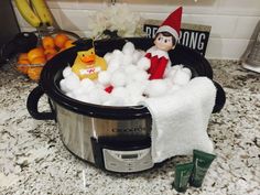 an elf is sitting in the middle of a crock pot filled with cotton