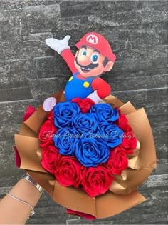 a person holding a bouquet of red, white and blue roses in their hand with mario on it