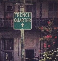 a green street sign sitting in front of a tall building