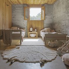 there are two beds in this room with wood paneling on the walls and floor