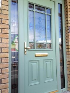 the front door is painted aqua green and has two sidelights on each side with glass panels