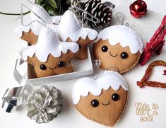 three gingerbread cookies decorated with white frosting and christmas decorations next to a silver ornament