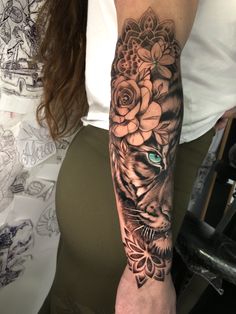 a woman's arm with a tiger and flowers on it