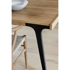 a wooden table with two chairs and a bowl on it's side, in front of a wood floor