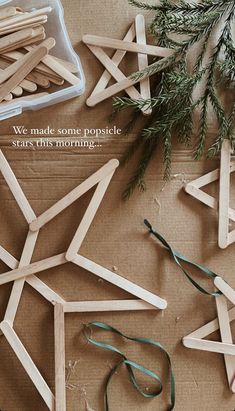 some popsicle sticks are laying on the ground next to christmas decorations and pine branches