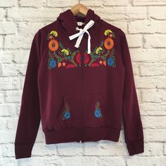 Women's Blue Floral Embroidered Mexican Sweatshirt Embroidered Mexican Hoodie With A Zipper - Sudadera Bordada Mexicana Made By Artisans In Chiapas, Mexico Color: Blue With Multi-Colored Embroidery Material: 50% Cotton & 50% Polyester Casual Tops With Multicolor Embroidery And Motif, Fall Embroidered Cotton Hoodie, Hooded Cotton Tops With Machine Embroidery, Traditional Fall Tops With Embroidered Hem, Traditional Embroidered Hem Tops For Fall, Fall Cotton Hoodie With Floral Embroidery, Cotton Hoodie With Floral Embroidery For Fall, Embroidered Cotton Hoodie For Spring, Hooded Tops With Machine Embroidery For Winter