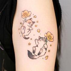 a woman with a cat tattoo on her arm and behind her is an orange flower