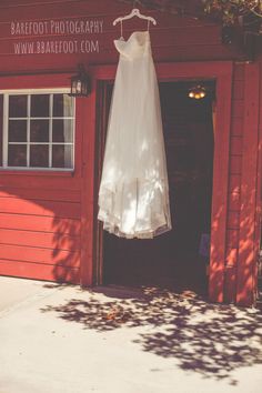 a white dress hanging on a red building