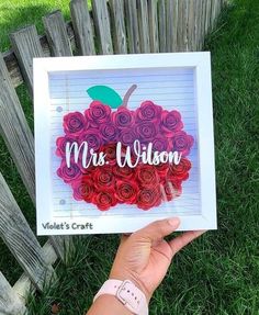 a hand holding up a card that says, mrs wilson with roses in the shape of an apple