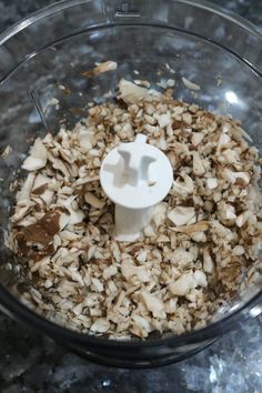 a food processor filled with chopped nuts on top of a counter