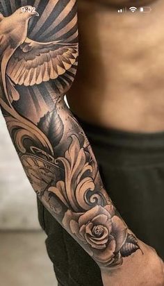 a man's arm with a bird and rose tattoo on the left side of his arm