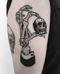 a man's arm with a skull and bones tattoo on the upper half of his arm