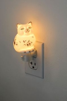 a light that is on the wall with a cat lamp attached to it's side