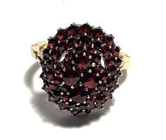 "Vintage 14K Yellow Gold Oval Bohemian Garnet Cluster Ring Victorian style Fifty-four deep burgundy colored round rose cut garnets create a gleaming cluster, fifty smaller round garnets surround the top four larger garnets. Simple adjustable band with split shoulders completes this gorgeous ring reminiscent of Victorian style. Band hallmarked \"14K\". Condition: Excellent Vintage Condition.  Dimensions: Ring Size: 8.5, Personalized adjustable band. Ring measure: garnet cluster 0.78\" (20mm) x 0.6\" (15mm), band width 1/16\" (2.5mm) on the center back. Weight: 6.97 grams." Fine Jewelry Garnet Cluster Ring, Fine Jewelry Round Cluster Ring With Garnet, Formal Round Garnet Cluster Ring, Garnet Gemstone Cluster Ring, Gold Oval Garnet Cluster Ring, Oval Garnet Cluster Ring In Gold, Heirloom Style Round Garnet Cluster Ring, Heirloom Style Garnet Cluster Ring, Heirloom Garnet Cluster Ring