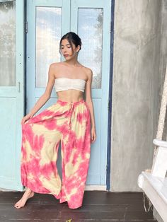 Step into a soft dreamscape of color with our Summer Tie-Dye Wide-Leg Pants. The perfect choice of vacation wear, these flared pants reflect free-spirited chic, letting you float through summer in unconfined comfort. Handcrafted from 100% Rayon, they offer exceptional breathability and a fluidic drape that keeps you cool and light as air all summer. It features an elasticated drawstring waist that offers an adjustable fit and side pockets for a practical flair. The vibrant tie-dye patterns captu Summer Festival Wide-leg Harem Pants, Summer Vacation Wide-leg Harem Pants, Flowy Bottoms For Summer Vacation, Summer Hippie Pants For Vacation, Hippie Multicolor Bottoms For Beach Season, Hippie Summer Pants For Vacation, Summer Hippie Vacation Pants, Hippie Summer Vacation Pants, Summer Vacation Hippie Pants