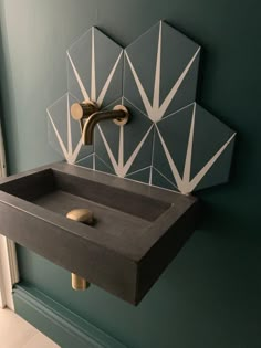 a bathroom sink sitting under a mirror next to a wall mounted faucet