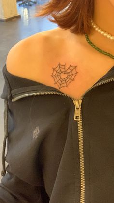 a woman with a spider web tattoo on her shoulder