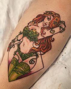 a woman with red hair and green leaves on her leg is shown in this tattoo design