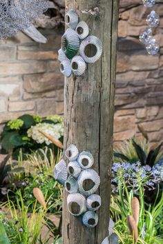 a wooden pole with several metal objects hanging from it