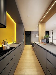 a long narrow kitchen with yellow accent lighting