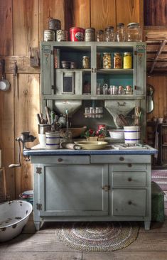 an old fashioned kitchen with lots of cupboards and bowls on the counter top,