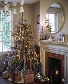 a decorated christmas tree sitting in front of a fire place