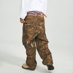 The Ink-Splashed Camo Cargo Pants in green offer a perfect fusion of vintage style and modern craftsmanship. Featuring a bold camo pattern with striking white ink-splatter detailing, these pants bring a unique twist to the classic cargo look. The distressed, ripped accents add a rugged edge, while the multi-pocket design ensures functionality. With adjustable waistband buckles and a leather logo patch on the back, these pants are crafted from premium 100% cotton and offer a slightly oversized fi Military Style Full Length Parachute Pants For Streetwear, Camouflage Streetwear Bottoms Full Length, Casual Paint Splatter Streetwear Bottoms, Camouflage Full-length Bottoms For Streetwear, Camouflage Full Length Bottoms For Streetwear, Baggy Military Bottoms For Streetwear, Full Length Camouflage Bottoms For Streetwear, Urban Camouflage Cotton Bottoms, Urban Style Camouflage Cotton Bottoms