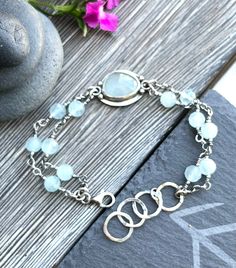 "light blue aquamarine encased in sterling silver bracelet. Dimensions: length 19cm/7,5\", best fits a 6,5\" - 7,5\" wrist;   The bracelet is slightly adjustable with hammered circles, oxidized and polished to enhance the detail of the metalwork. The bracelet is handcrafted with care in my studio. Purchases are nicely packaged, ready for gift giving or a special treat for yourself.  Matching ring is available in my shop: https://www.etsy.com/listing/1519668690/sterling-silver-ring-with-faceted?c Adjustable Aquamarine Bracelets With Natural Stones, Handmade Adjustable Aquamarine Bracelet, Handmade Silver Amazonite Beaded Bracelets, Silver Bracelets With Amazonite And Natural Stones, Silver Amazonite Bracelet As Gift, Silver Amazonite Bracelet For Gift, Handmade Aquamarine Bracelet, Adjustable Silver Aquamarine Bracelets, Adjustable Silver Aquamarine Bracelet