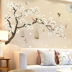 the living room is decorated with white flowers and birds flying in the tree wall decals