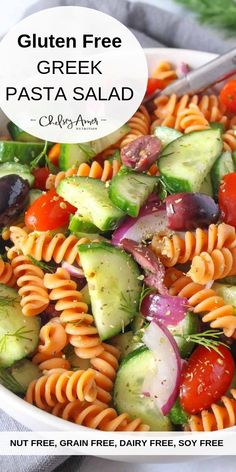 a pasta salad with cucumbers, tomatoes, and other vegetables in a white bowl