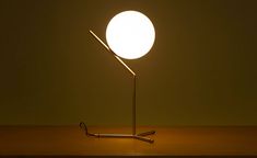 a light that is sitting on top of a wooden table next to a metal pipe