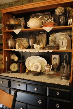 an antique china cabinet with many items on it